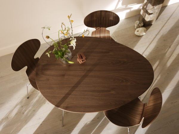 Die elliptische Tischplatte ist in Furnier Natur / Wallnuss verarbeitet. Das Untergestell in Chrom verleiht dem Tisch seinen eleganten Charakter.
