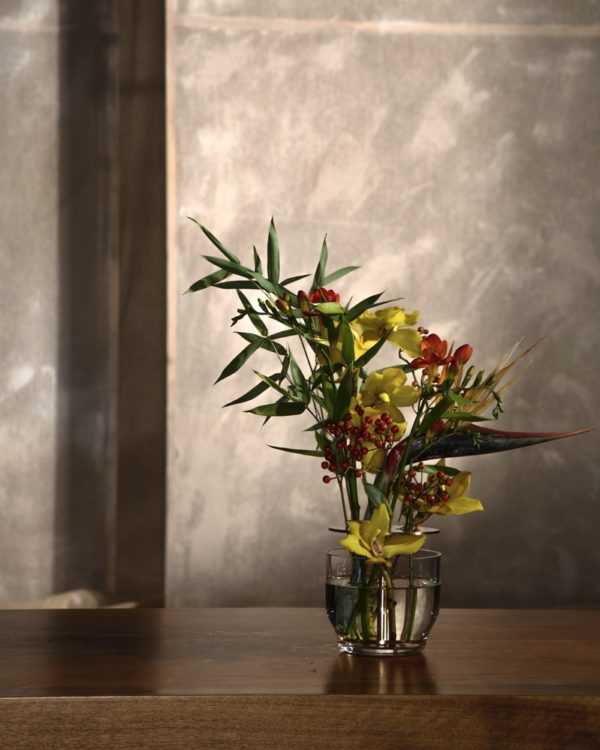 Die Vase hebt jede jeder einzelnen Blume hervor, vom Stiel bis zur Blütenkrone und ist in rostfreien Stahl oder in Messing erhältlich.