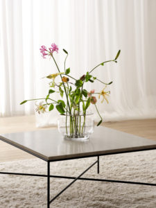 Die Vase hebt jede jeder einzelnen Blume hervor, vom Stiel bis zur Blütenkrone und ist in rostfreien Stahl oder in Messing erhältlich.