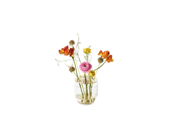 Die Vase hebt jede jeder einzelnen Blume hervor, vom Stiel bis zur Blütenkrone und ist in rostfreien Stahl oder in Messing erhältlich.