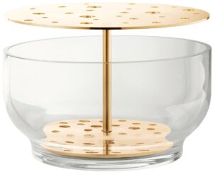 Die Vase hebt jede jeder einzelnen Blume hervor, vom Stiel bis zur Blütenkrone und ist in rostfreien Stahl oder in Messing erhältlich.