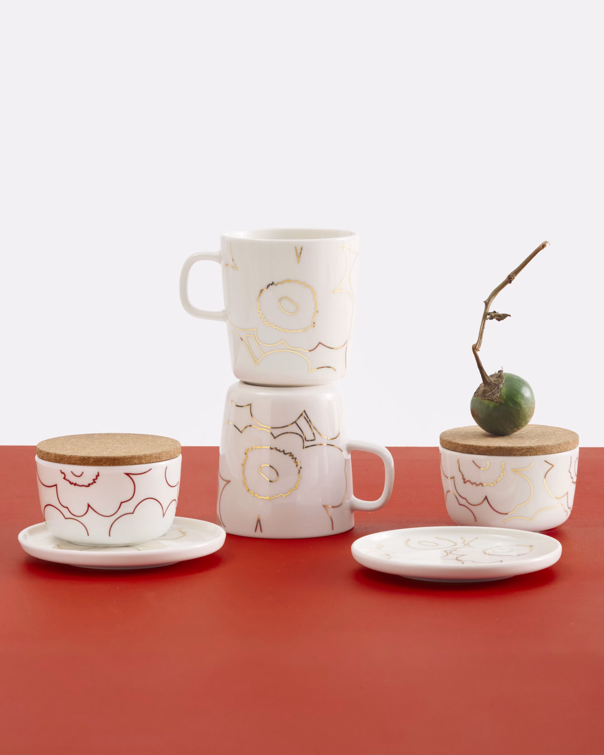 Die Oiva-Tasse ist aus weissem Steingut gefertigt und mit dem goldenen Piirto Unikko-Muster versehen. Aufgrund der goldenen Metalldetails empfehlen wir, die Tasse per Hand zu waschen. Dieses Produkt ist nicht für die Mikrowelle geeignet.