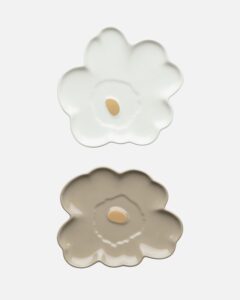Dieses Set enthält zwei kleine 13 cm grosse Unikko-Blumenteller. Ein Teller ist aus braunem Steingut und der andere aus weissem Steingut. Beide Teller haben in der Mitte ein goldenes Metalldetail.