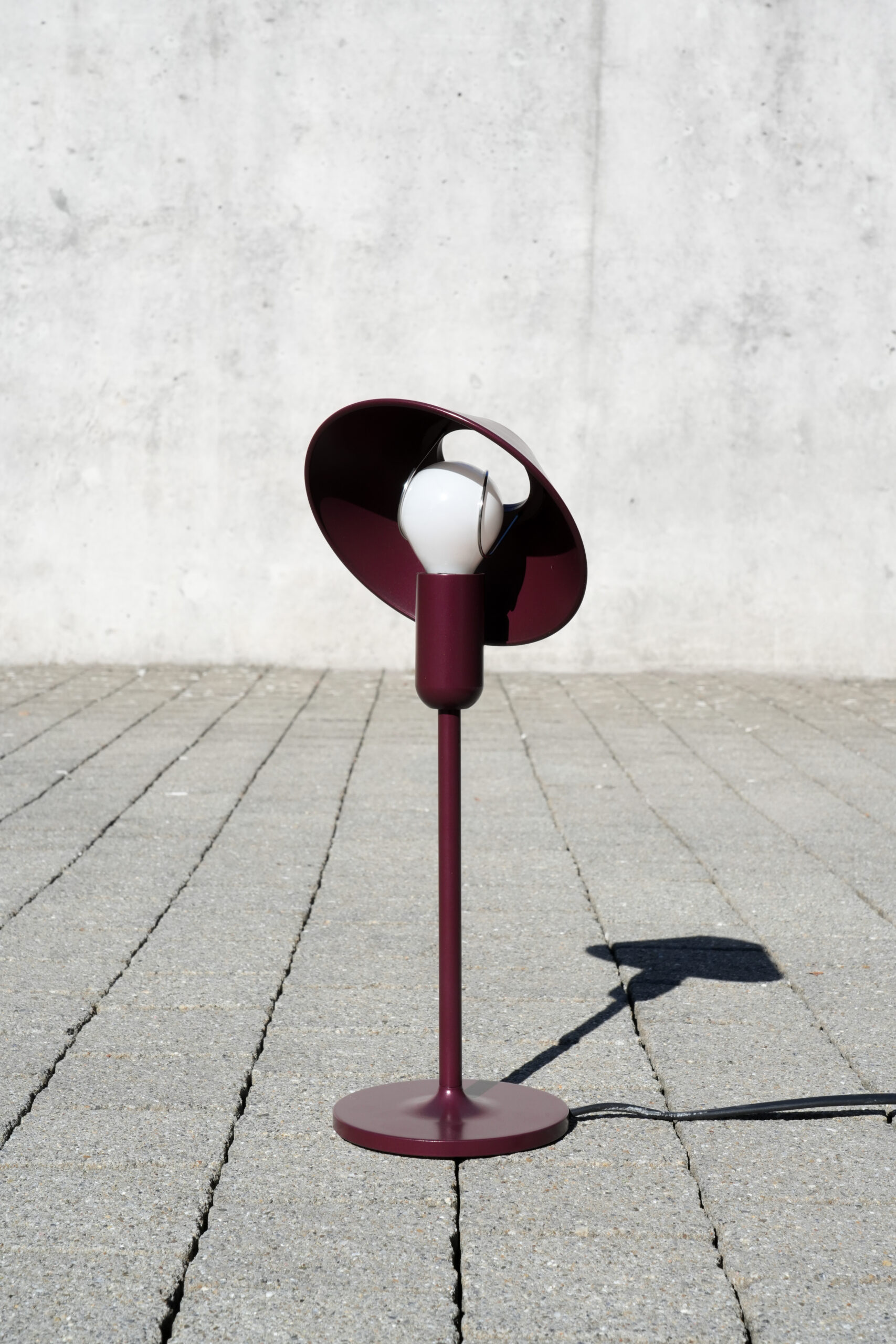 AVA ist eine Tischleuchte mit minimalistischem Sockel und E14 Fassung, auf dessen Lichtkopf spielerisch ein Hut tanzt. Ein behütetes Drückteil aus dem Baltensweiler Archiv wird erneut in Szene gesetzt.
